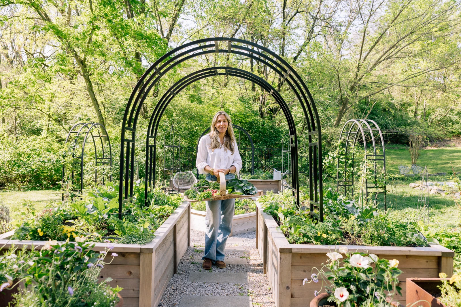 Nicole in front of two steel metal arch trellises. Nicole Arch Trellises.