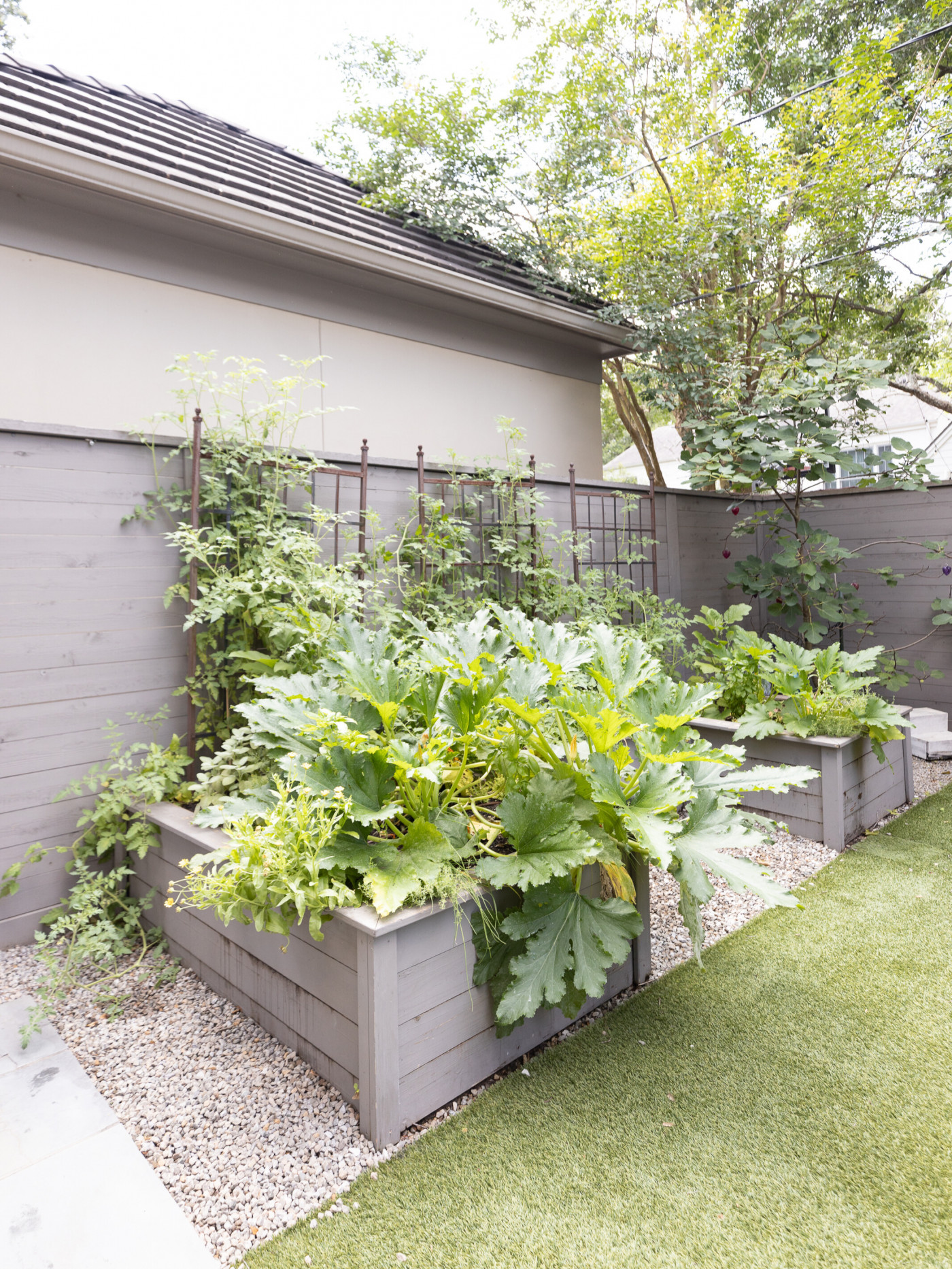 keyhole garden with gray stained cedar beds against fence