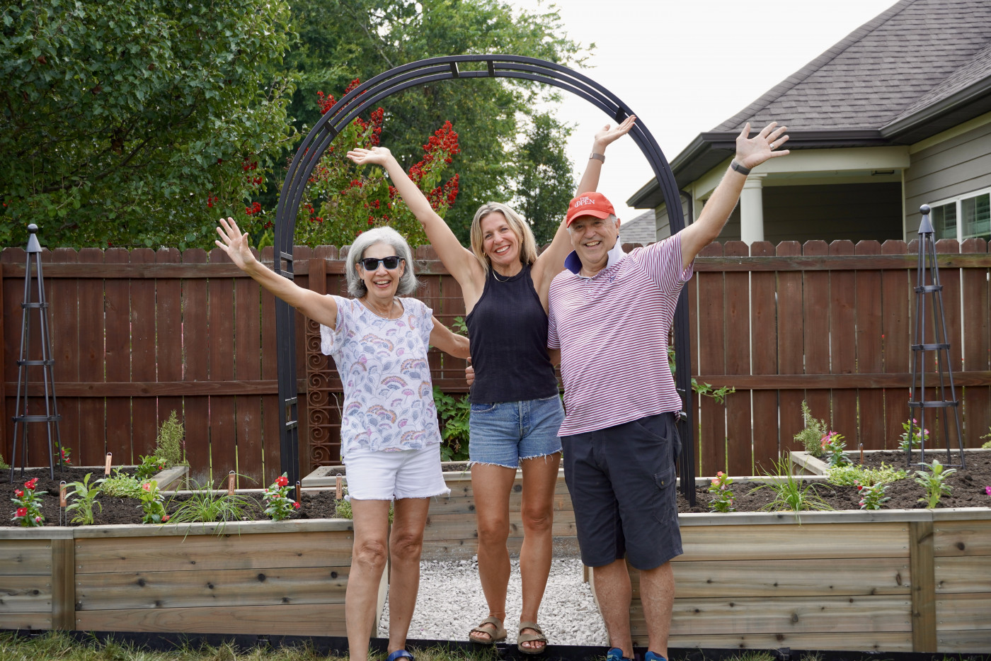 Seniors and Nicole Burke smiling with a cedar raised bed garden.
