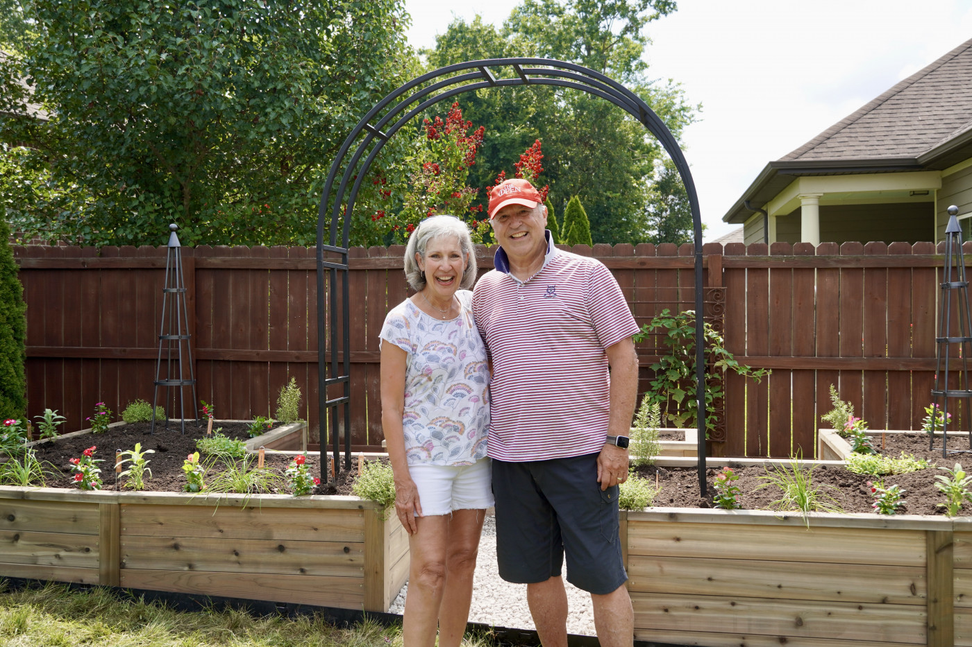 A senior woman and a senior man with a garden smiling.