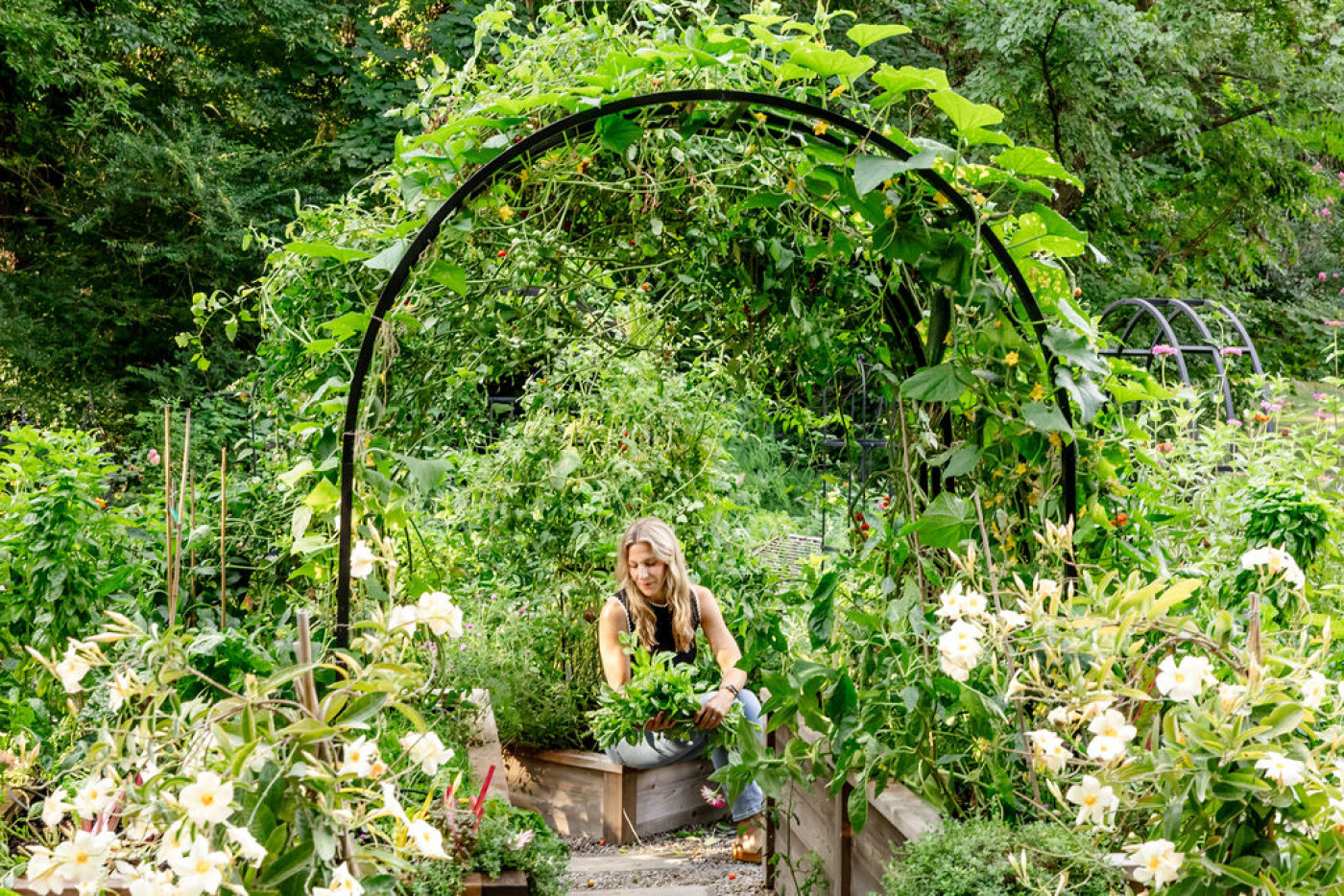 A woman sitting on the edge of a cedar raised bed