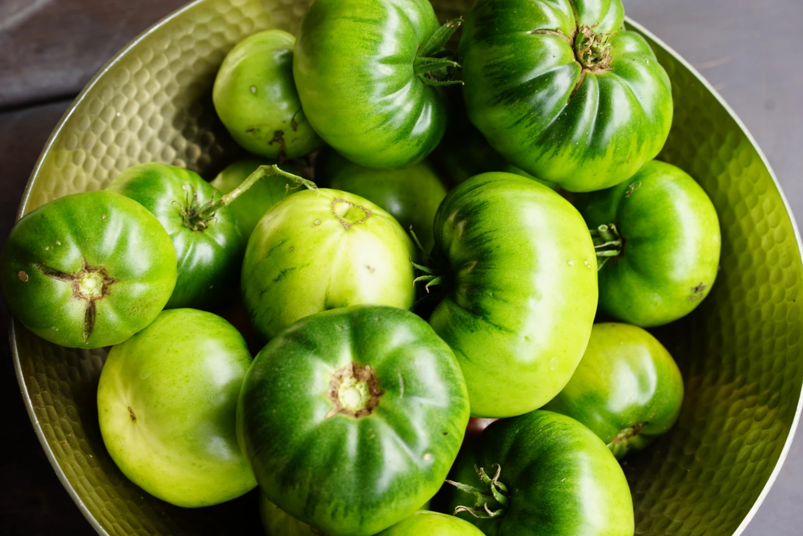 green tomatoes in a gold bowl