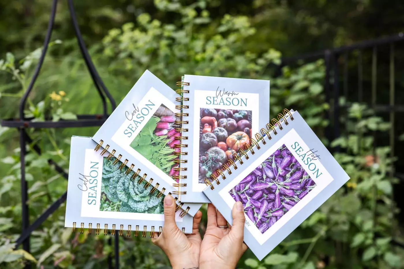 hands holding 4 Gardenary seasonal planners