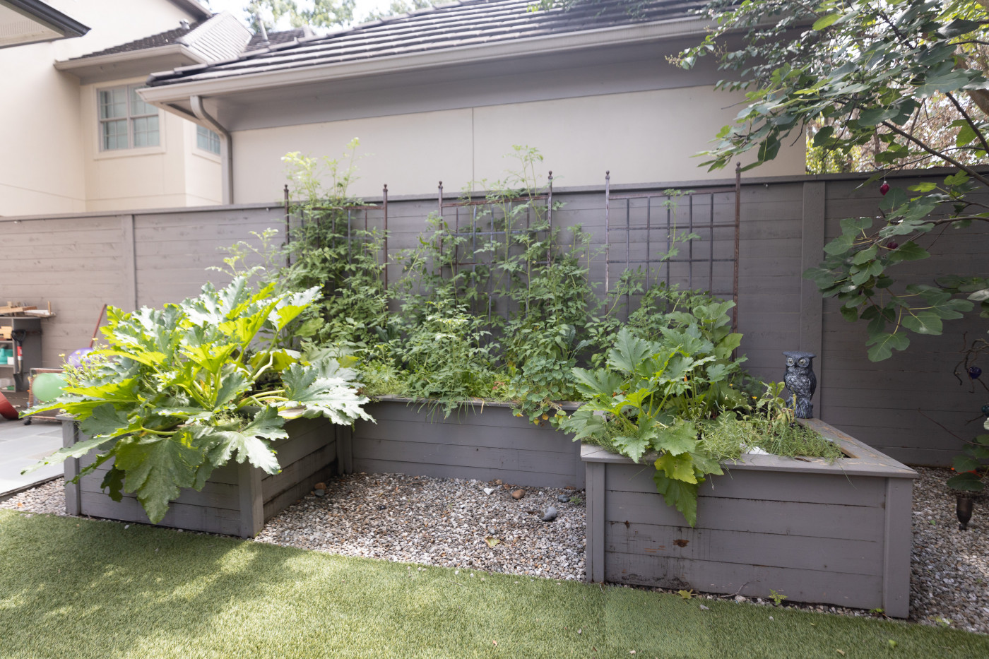 keyhole garden with gray stained cedar beds and panel trellises