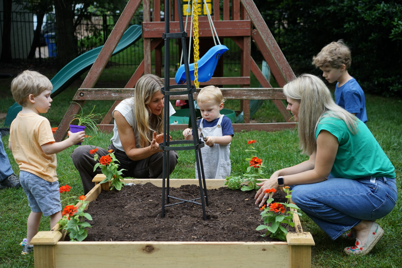 Children planting their first seeds in the garden.