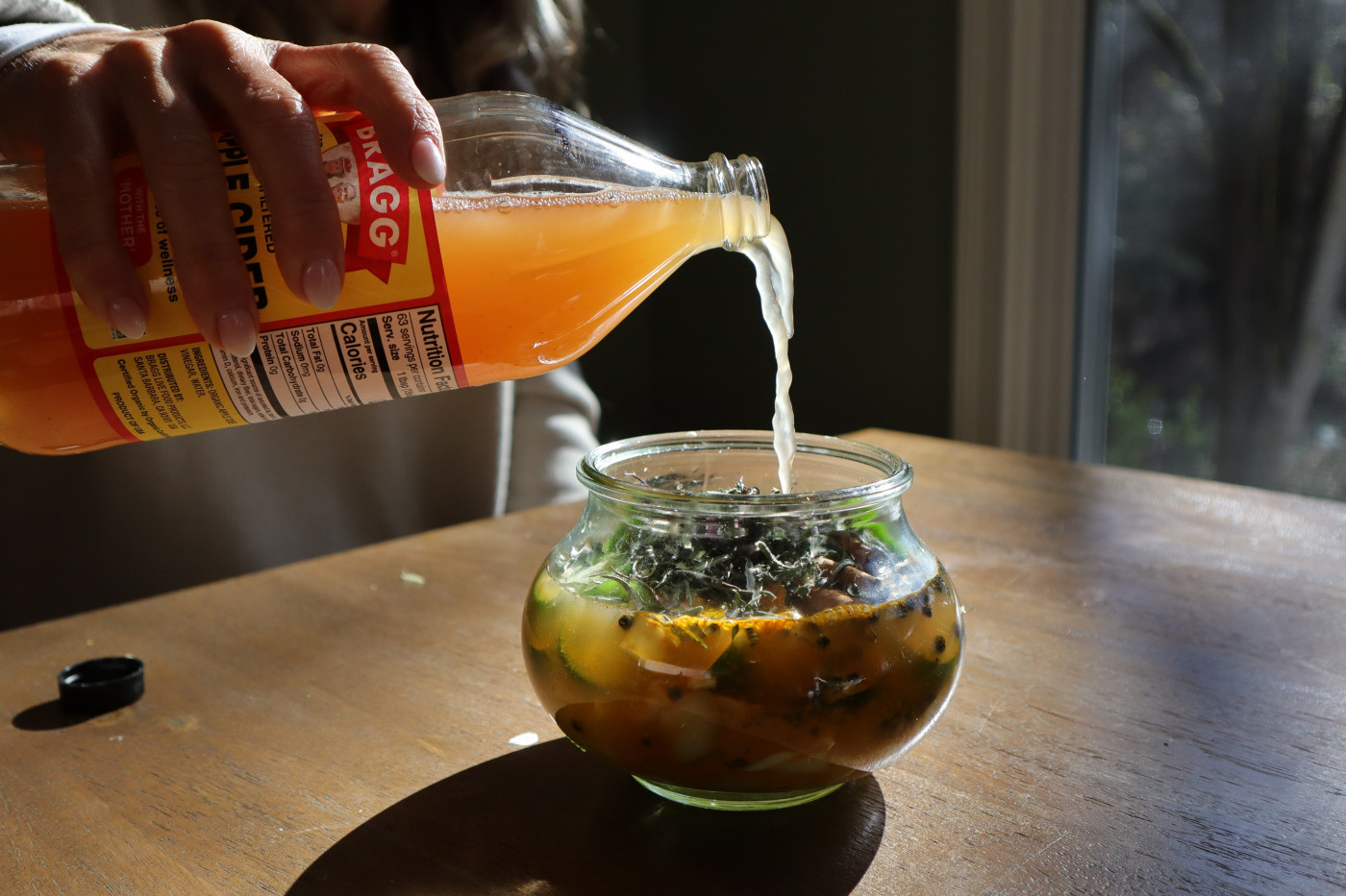 Apple cider vinegar being poured into a small glass